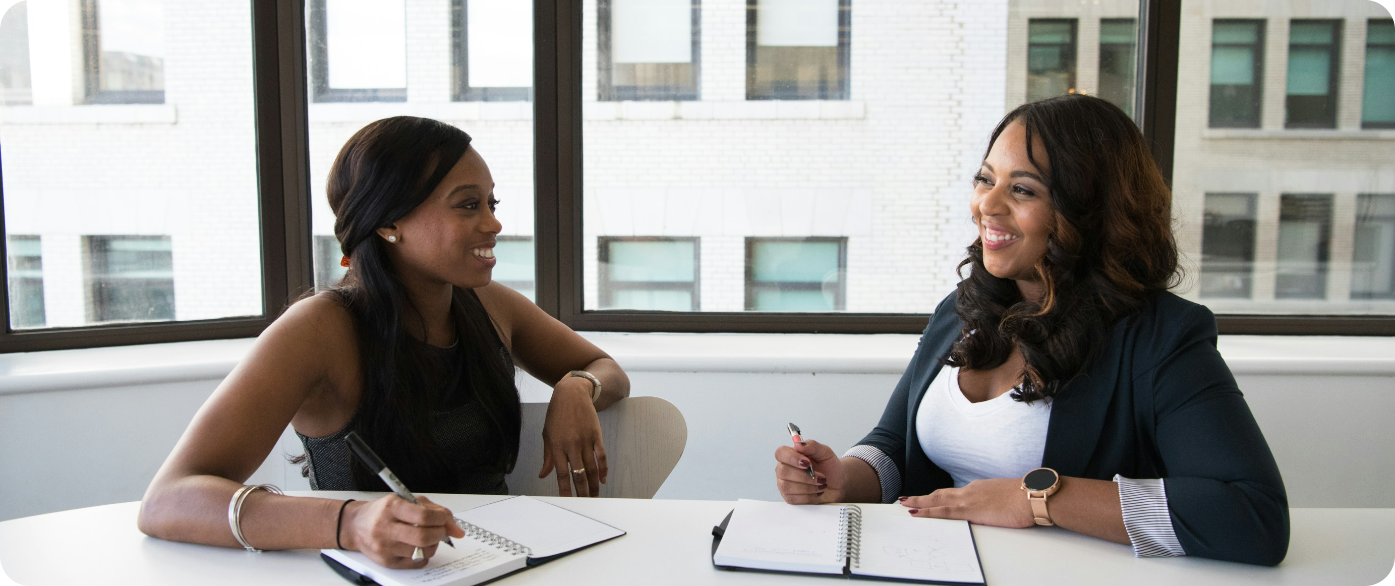 Mother with two children on a sofa - one holding a tablet, the other a baby